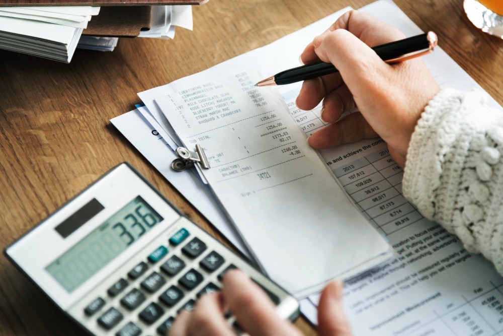empresa epp faturamento anual sendo feito por uma pessoa utilizando sua calculadora e os dados financeiros da empresa.
