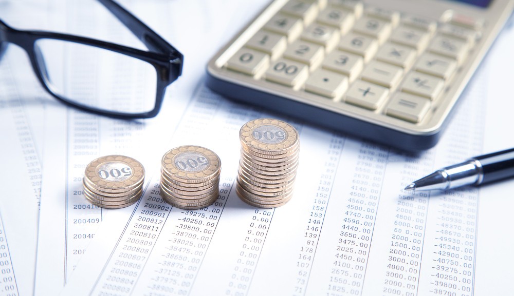 imagem representando um valor simbolico de quanto desconta inss e uma calculadora junto com documentos financeiros