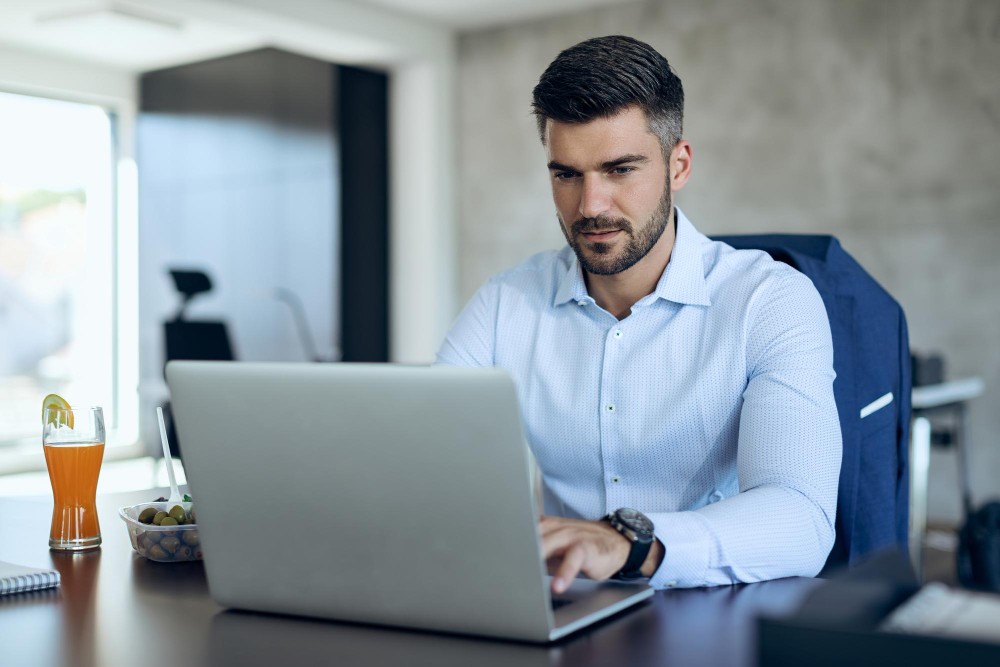 uma pessoa trabalhando em seu notbook para sua propria empresa que utiliza o modelo de Sociedade Limitada Unipessoal